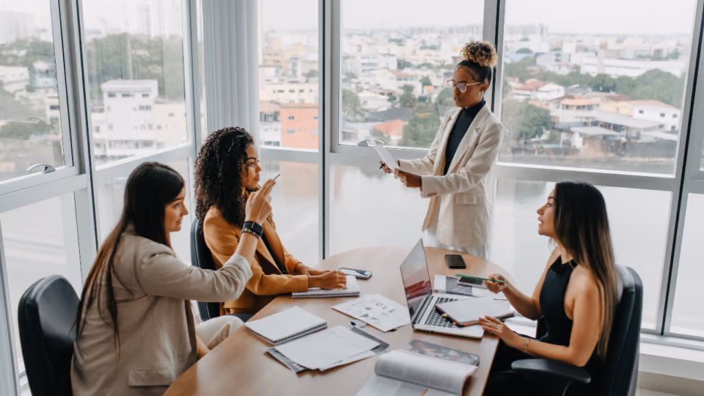 Responsable présentant un document à son équipe autour d’une table
