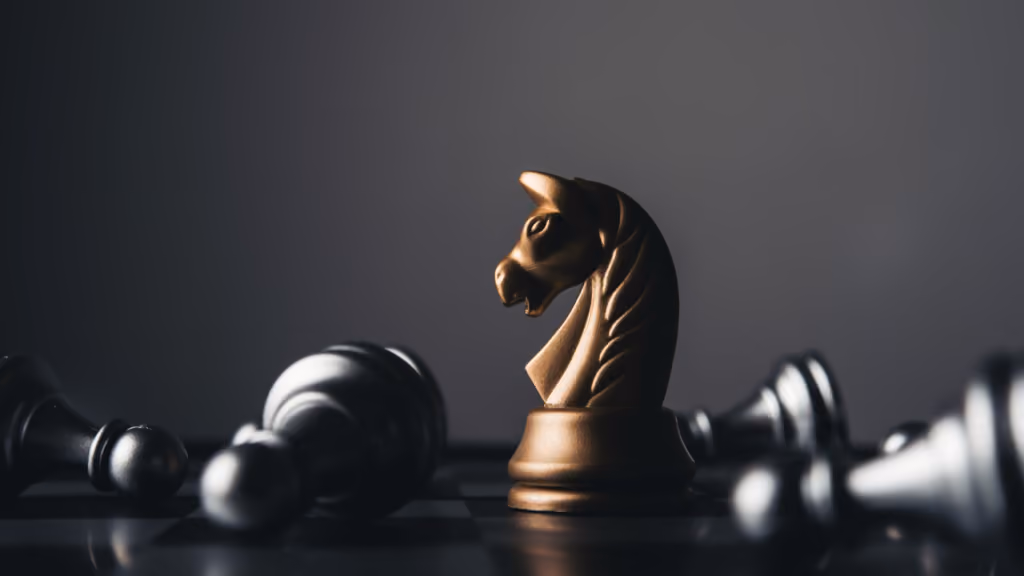 Cavalier doré debout parmi des pièces d’échecs renversées